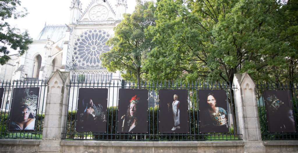 Portraits de femmes prises en charge par la Maison des femmes de Saint-Denis, posant en reines et exposés sur les grilles du jardin de la Basilique Cathédrale.