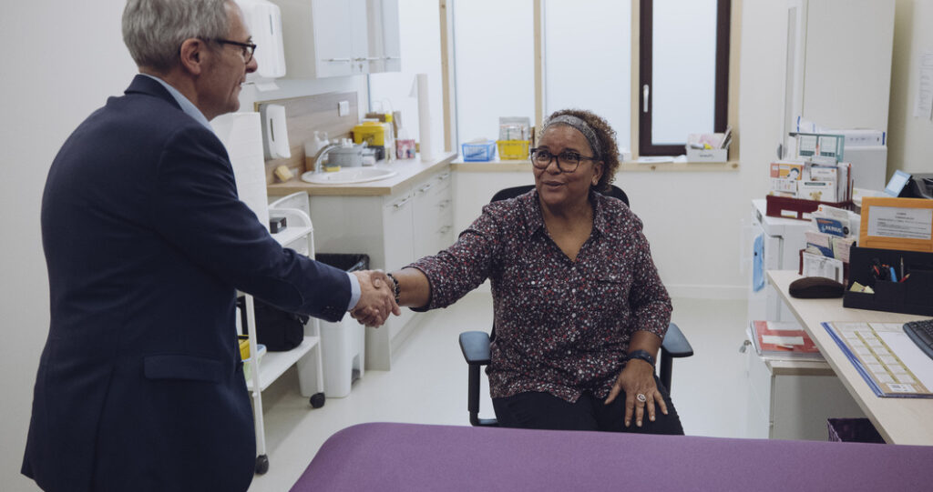 Le Président du Département Stéphane Troussel salue une agente départementale de la PMI Marie-Claire Chevalier de Villetaneuse.