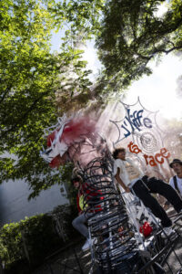 Des participant·es défilent autour d’un char artistique pendant la Grande parade métèque.
